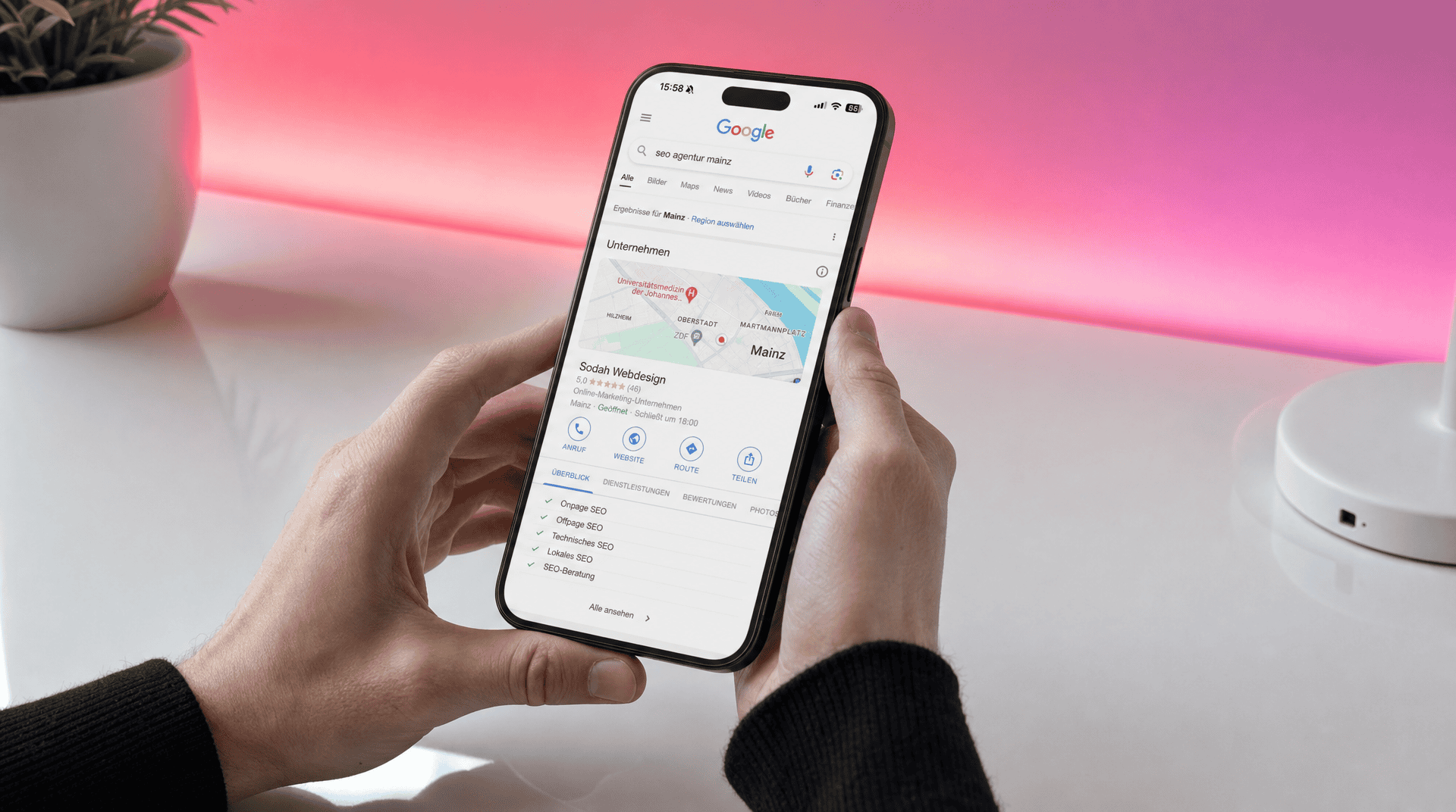 SEO Agentur Mainz: Google Suchergebnis für lokale Unternehmen Smartphone zeigt Google-Suchergebnis für "seo agentur mainz" mit Profil von Sodah Webdesign und lokalen Angeboten.