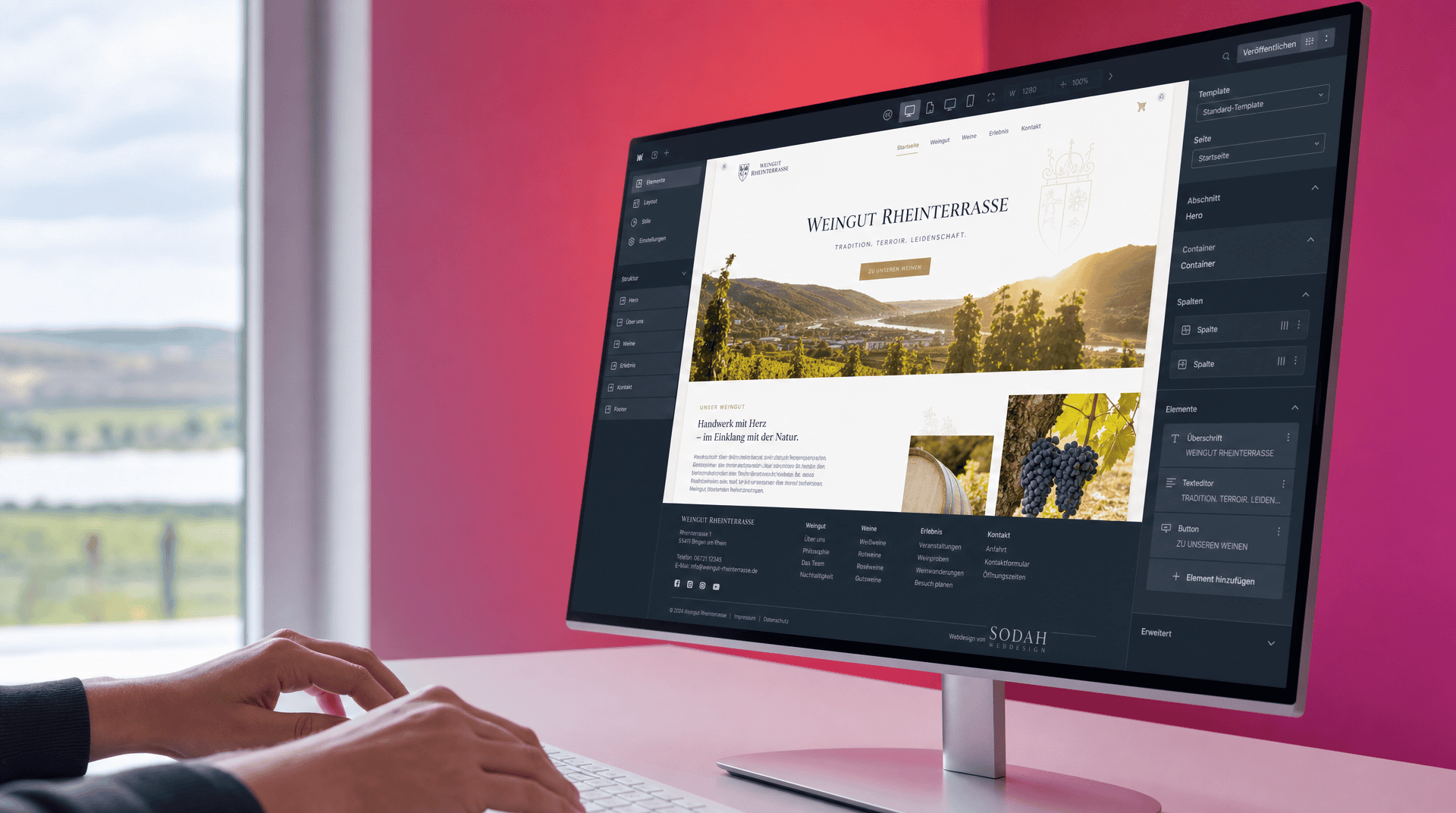 Hände an Tastatur: Webdesigner bearbeitet Weingut-Website in einem CMS am großen Monitor.