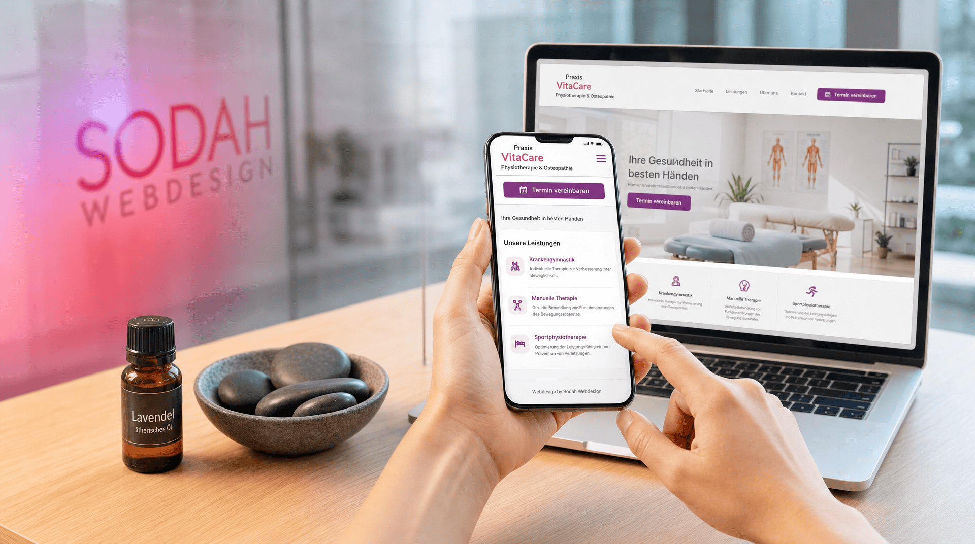 Responsive Webdesign Therapiepraxis VitaCare Hände halten Smartphone mit mobiler Therapie-Website. Im Hintergrund Laptop mit Desktop-Ansicht, Sodah Webdesign Logo, Lavendelöl, Massagesteine.