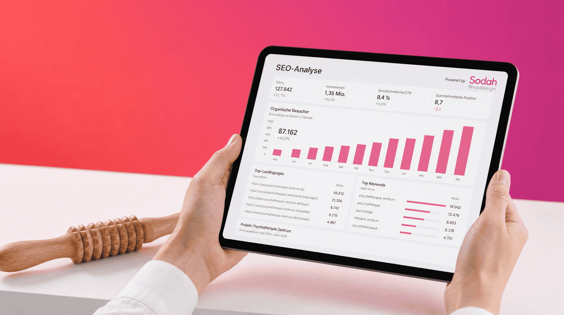 SEO-Analyse für Therapiepraxen Hände halten ein Tablet mit SEO-Statistik. Daneben liegt eine hölzerne Massagerolle.